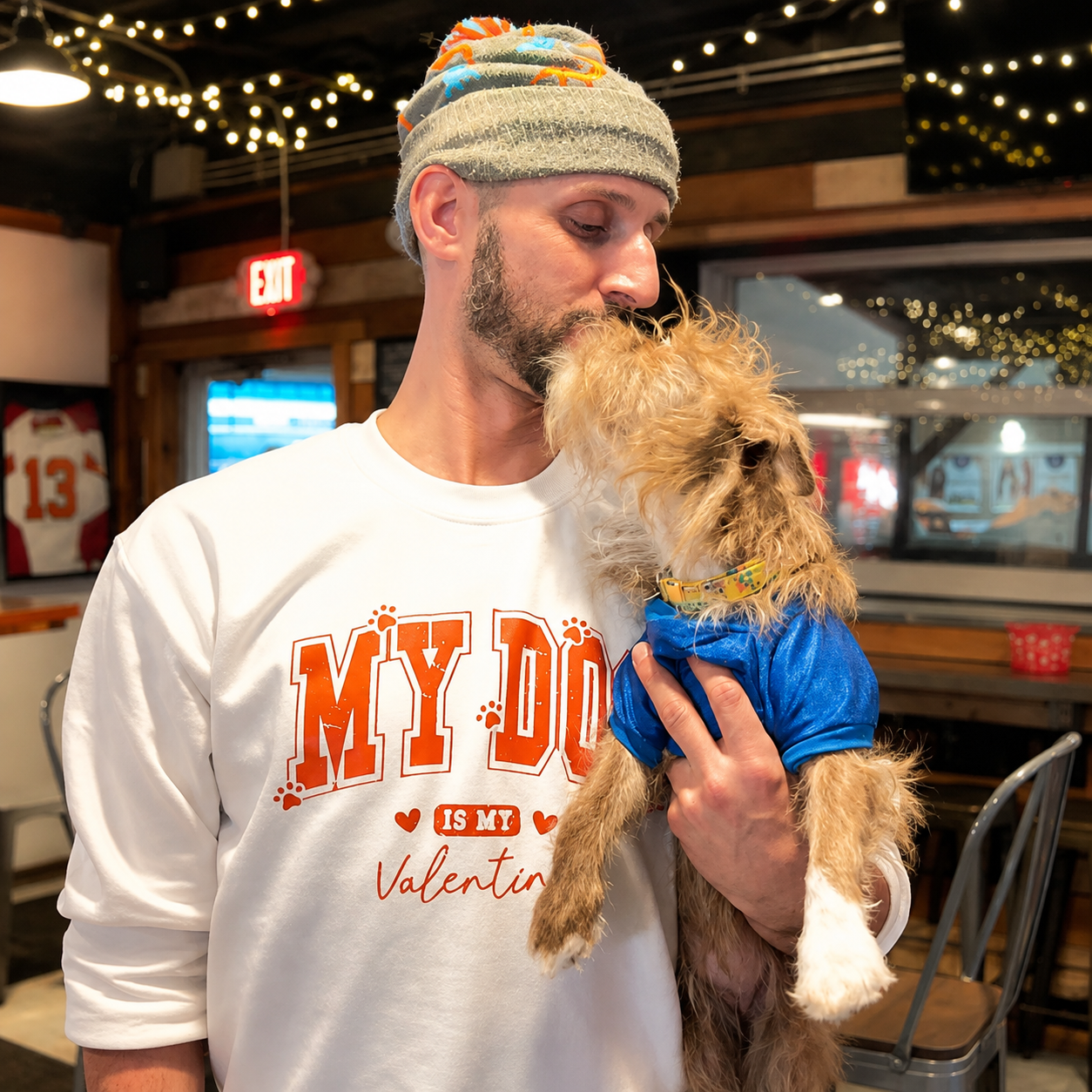 Joseph holding his terrier up for a kiss while wearing a My Dog Is My Valentine sweatshirt