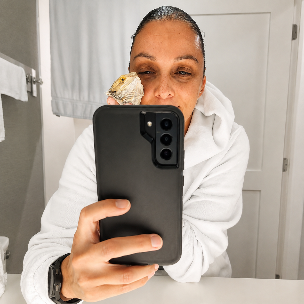 Marlena taking a mirror selfie with her bearded dragon perched beside her face